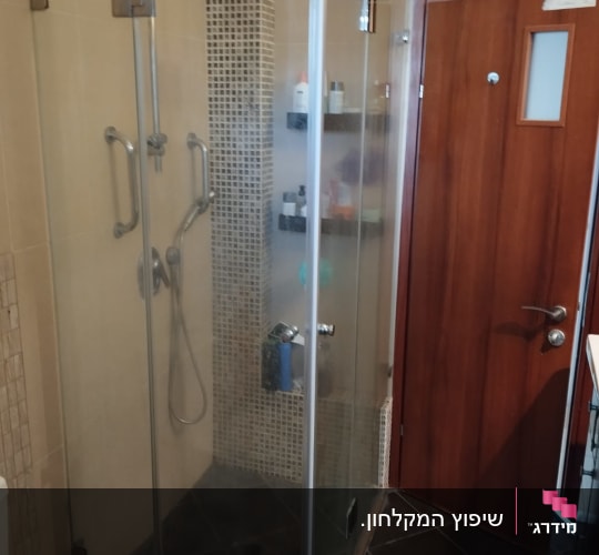 מקלחון זכוכית פינתי בעל דלתות פתיחה המותקן בחדר רחצה